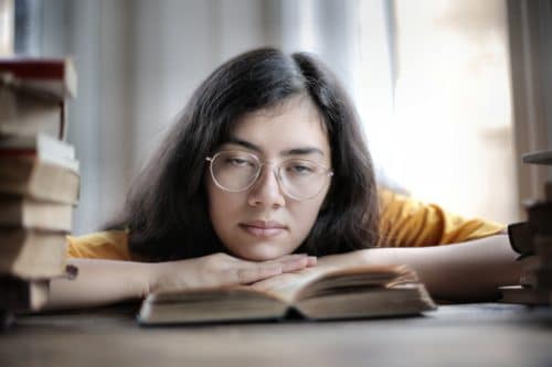 Person falling asleep on an open book.