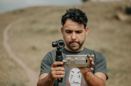 A filmmaker looks into a camera.