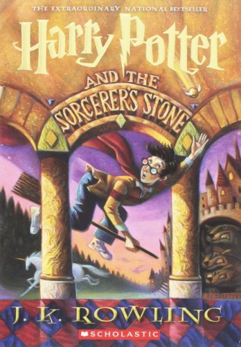 Cover of the book, Harry Potter and the Sorcerer's Stone: a boy in glasses rides a broomstick through the air.
