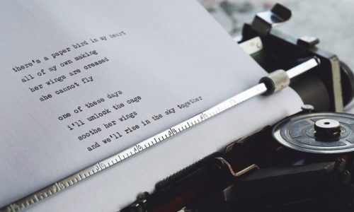 Close-up of a paper in a typewriter with a poem typed on it.