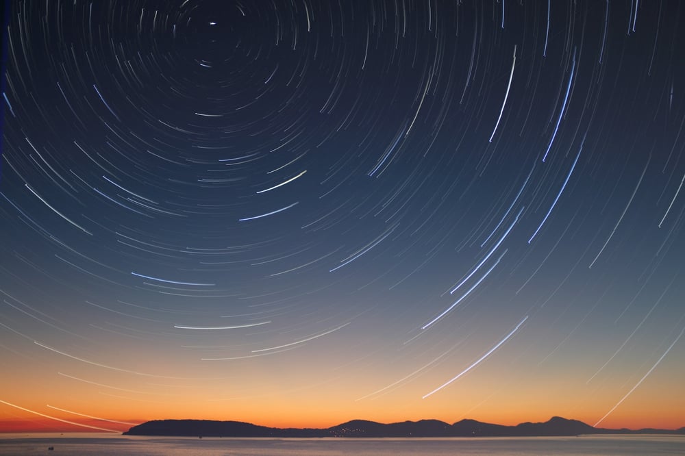 A circle of shooting stars in a desert sky.