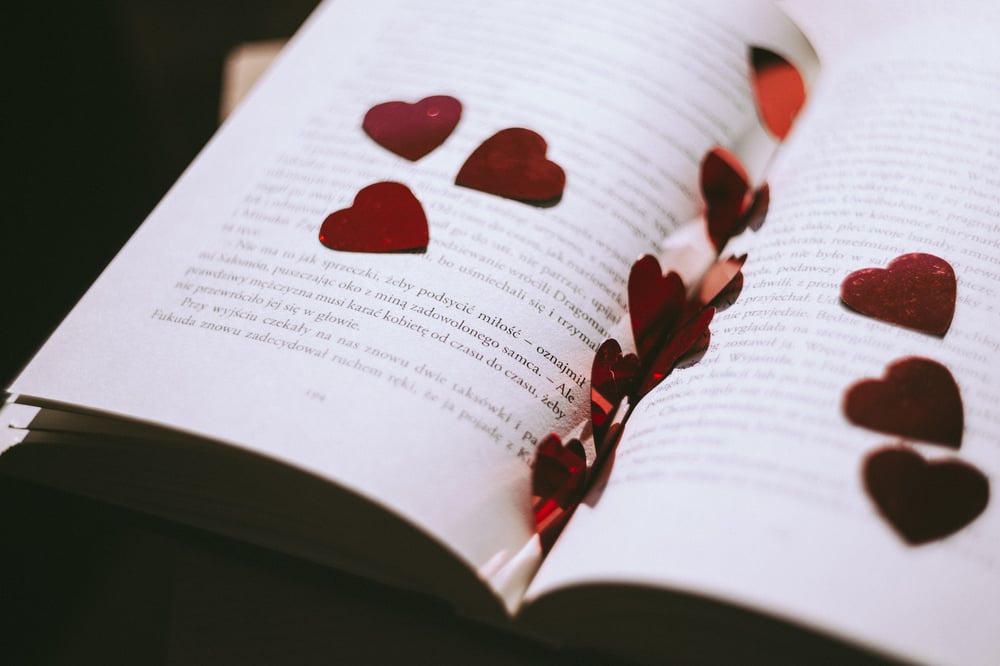 Little red flowers scattered on an open book.