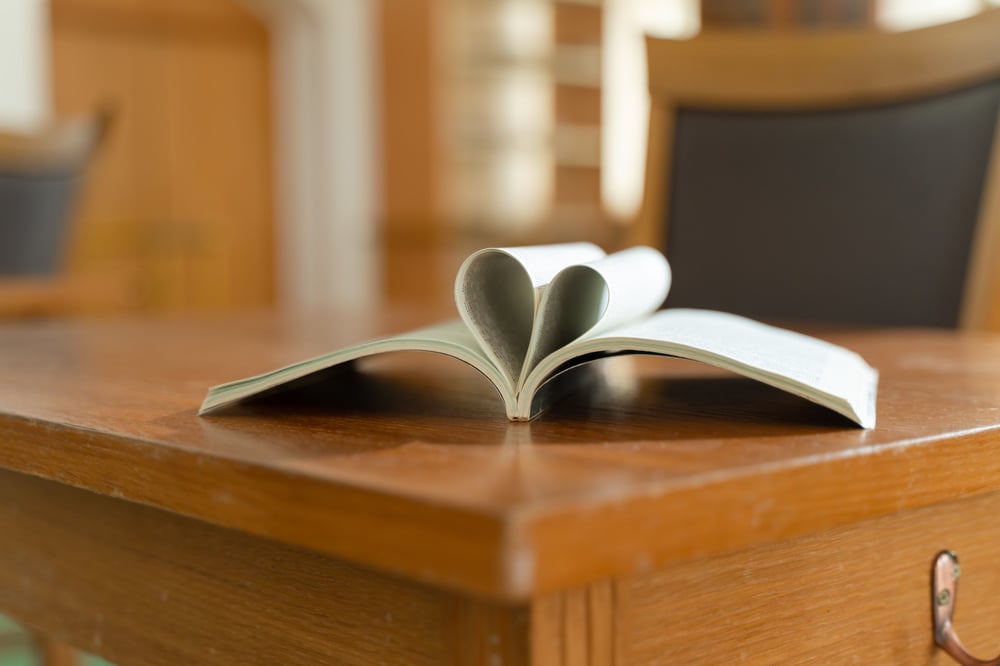 An open novella with its center pages folded into the shape of a heart.