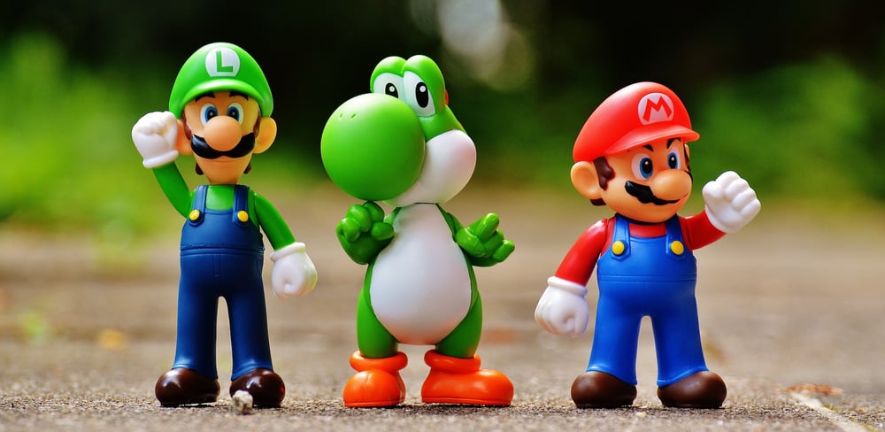 A row of figurines of Luigi, Yoshi, and Mario from Super Mario Brothers.