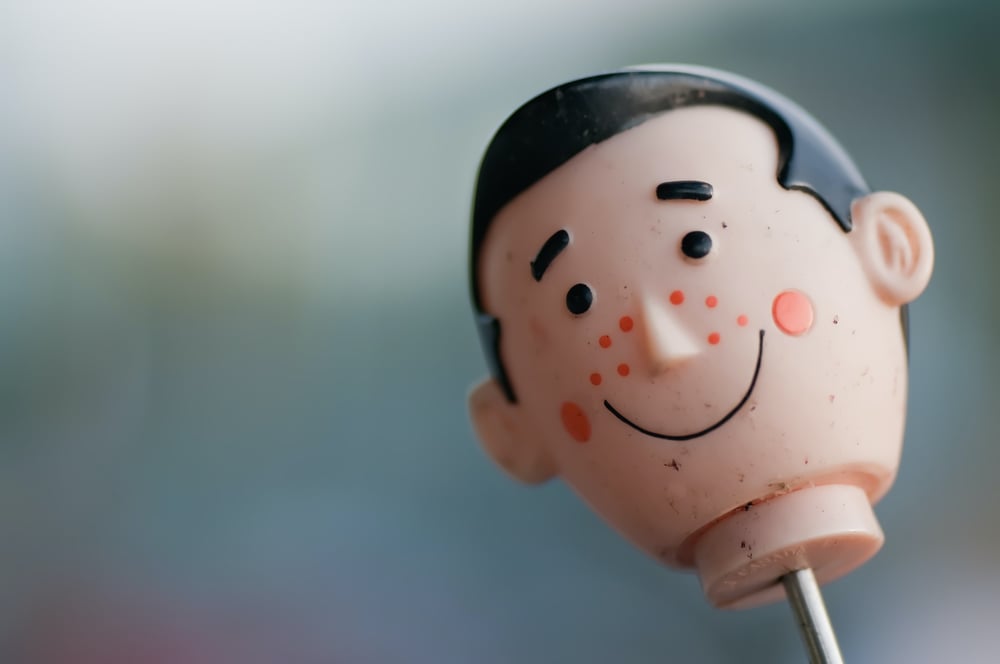 The head of a plastic toy man on a stick.