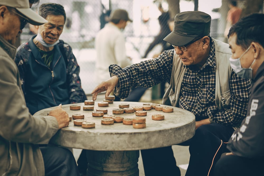 Older men play a game of Chinese chess in public.
