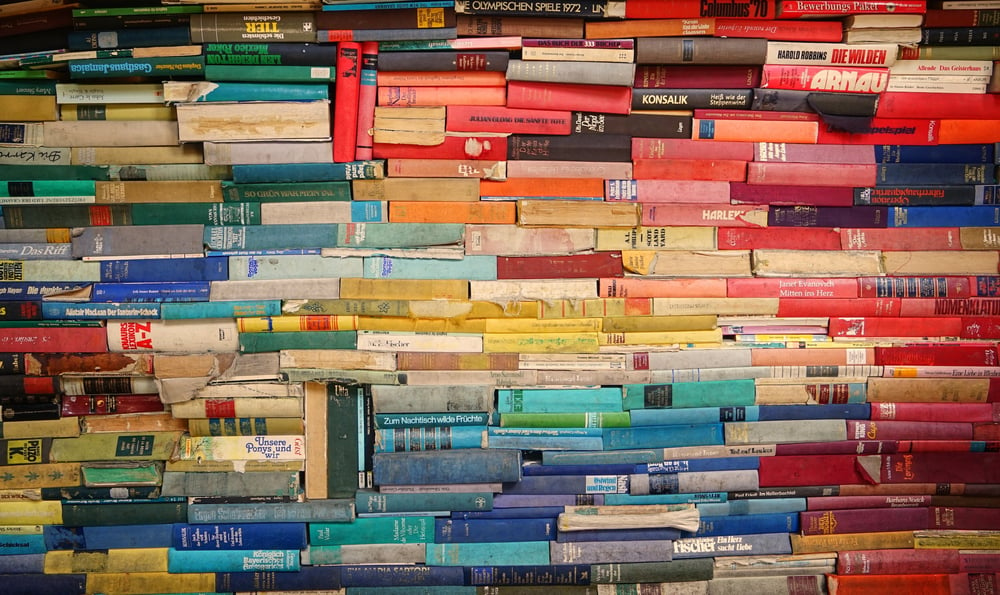 A stack of multi-colored published books.