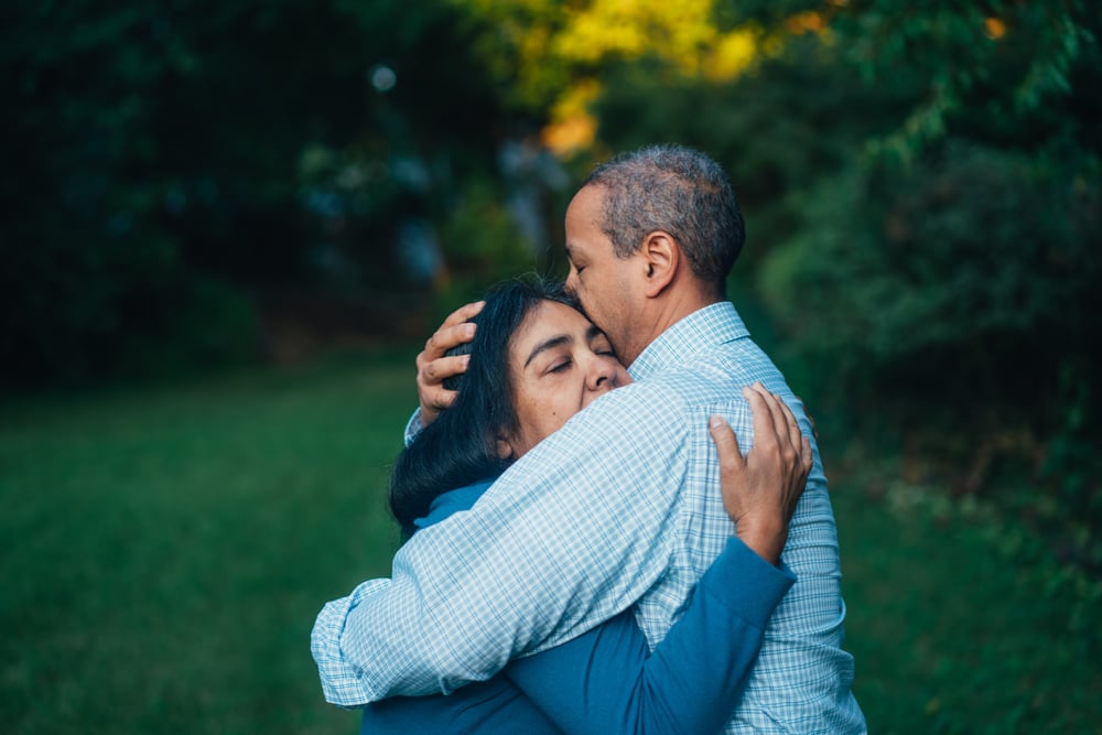 An older couple embraces.