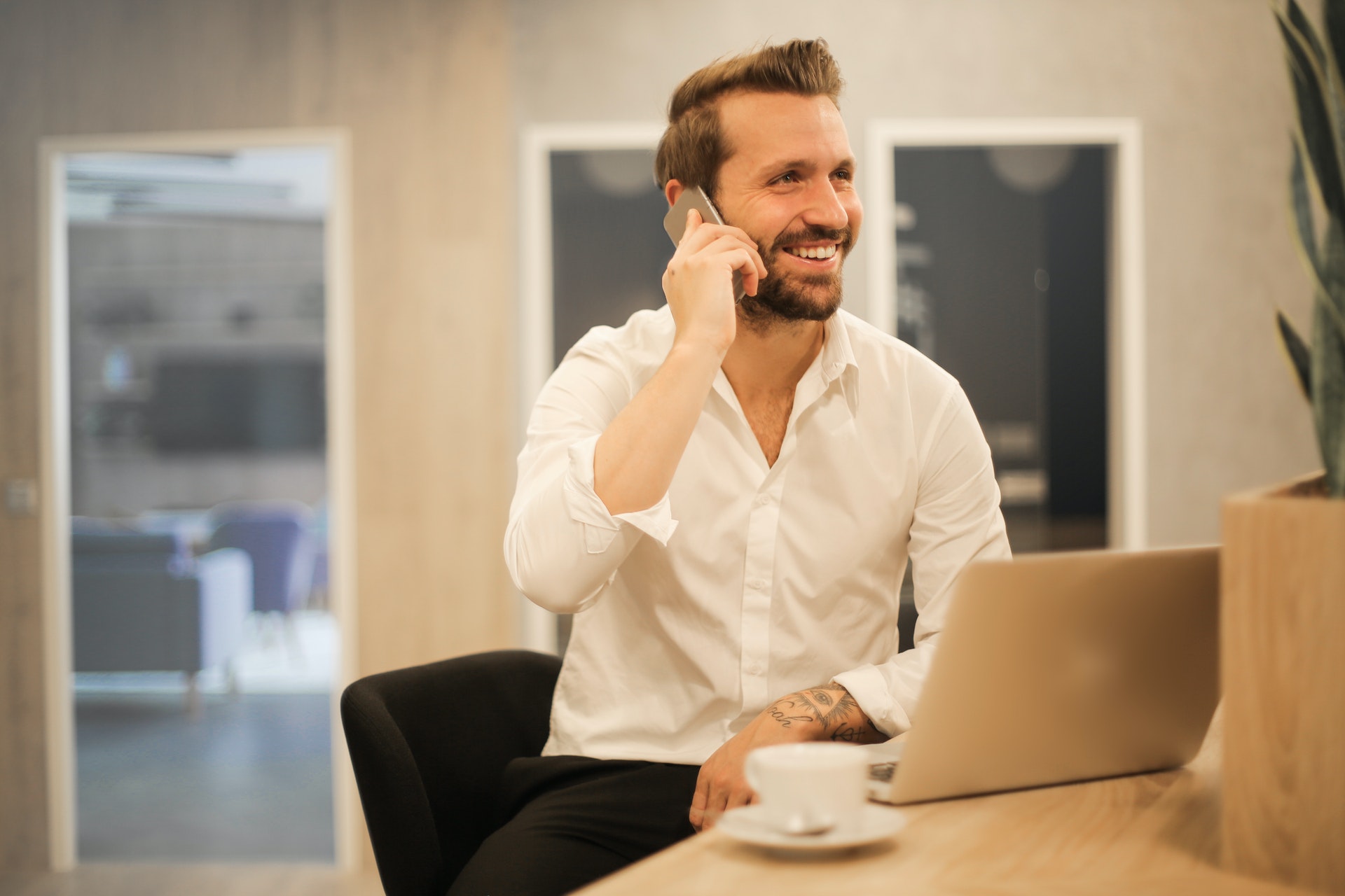 A smiling person talks on the phone.