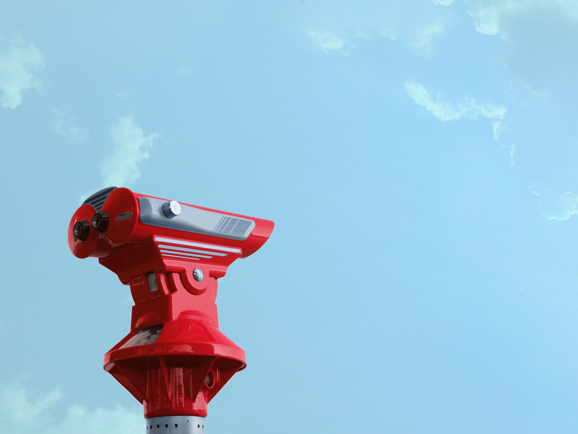 Red telescope against a blue sky.