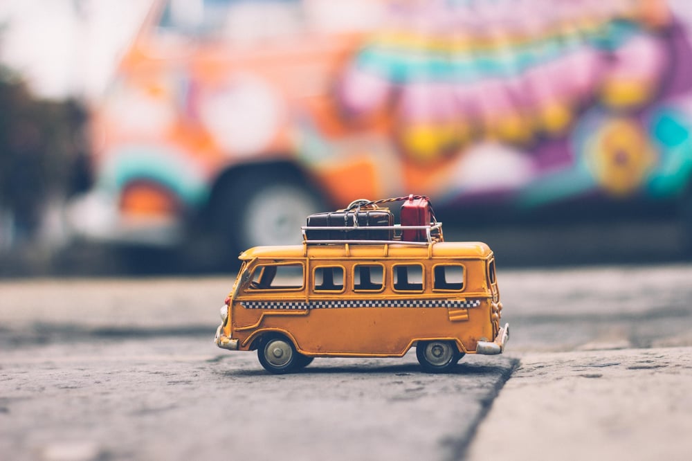 A little toy bus on a sidewalk.