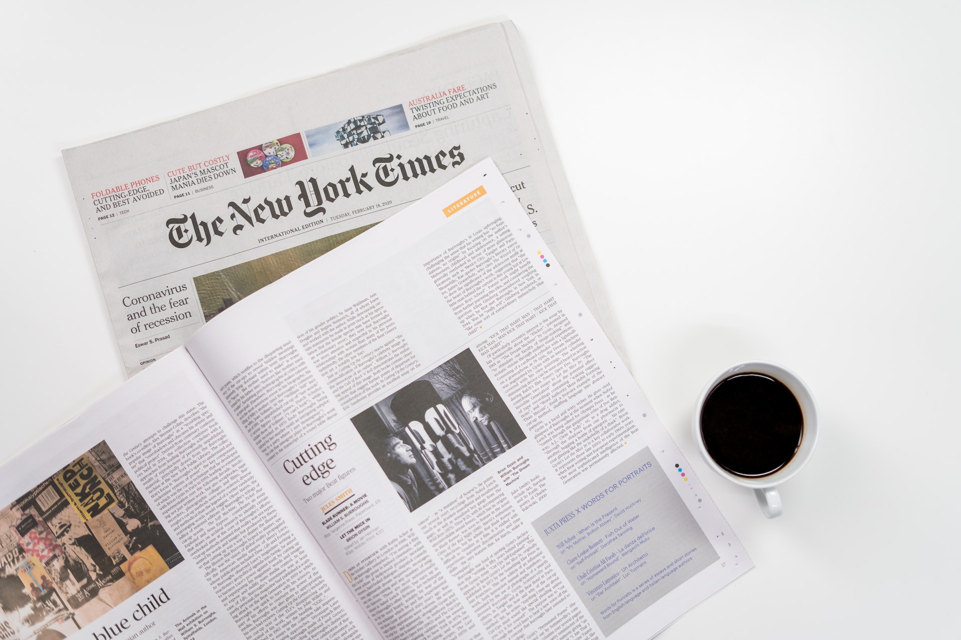 A newspaper and magazine on a white surface.