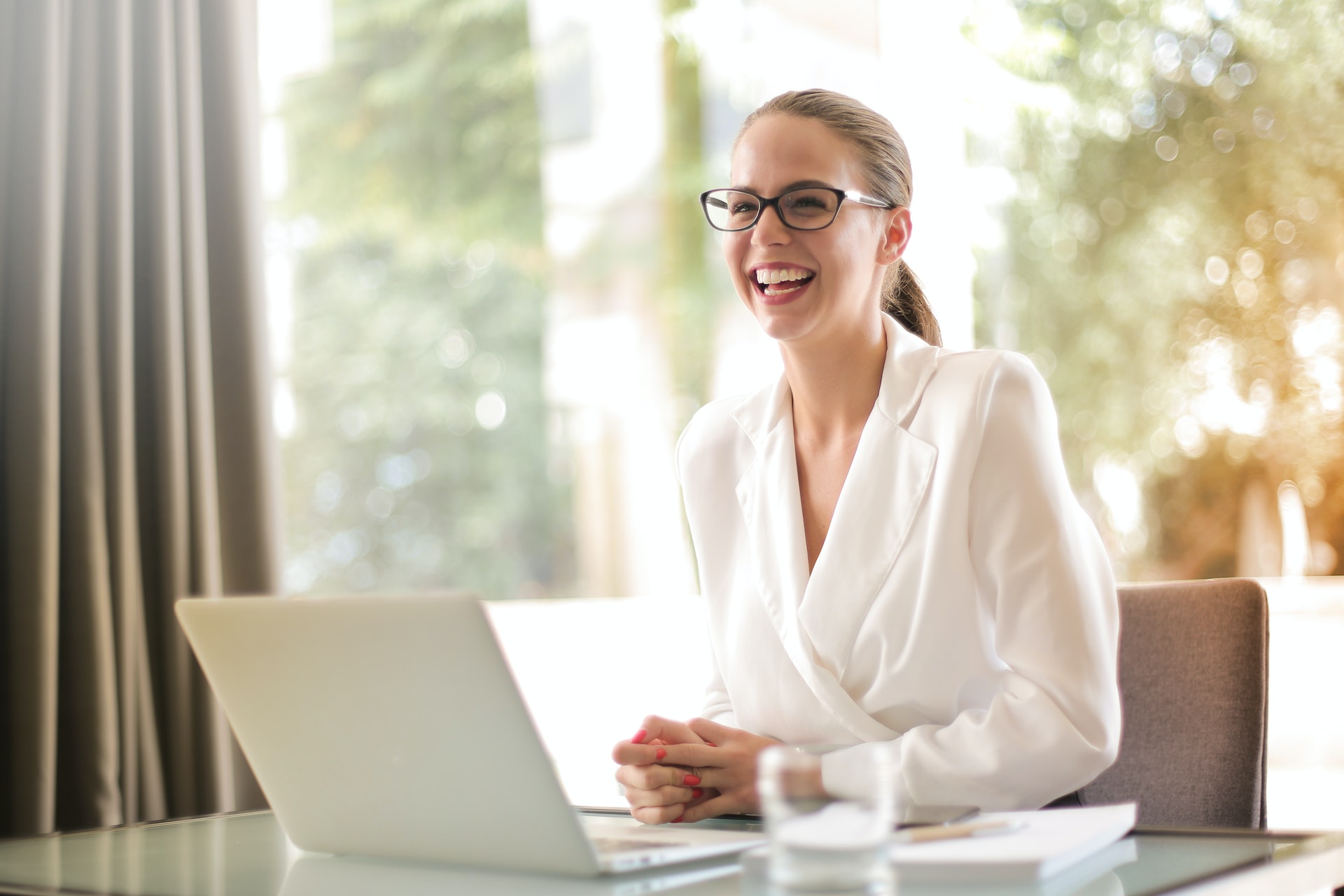 A literary agent sits at a desk, smiling.