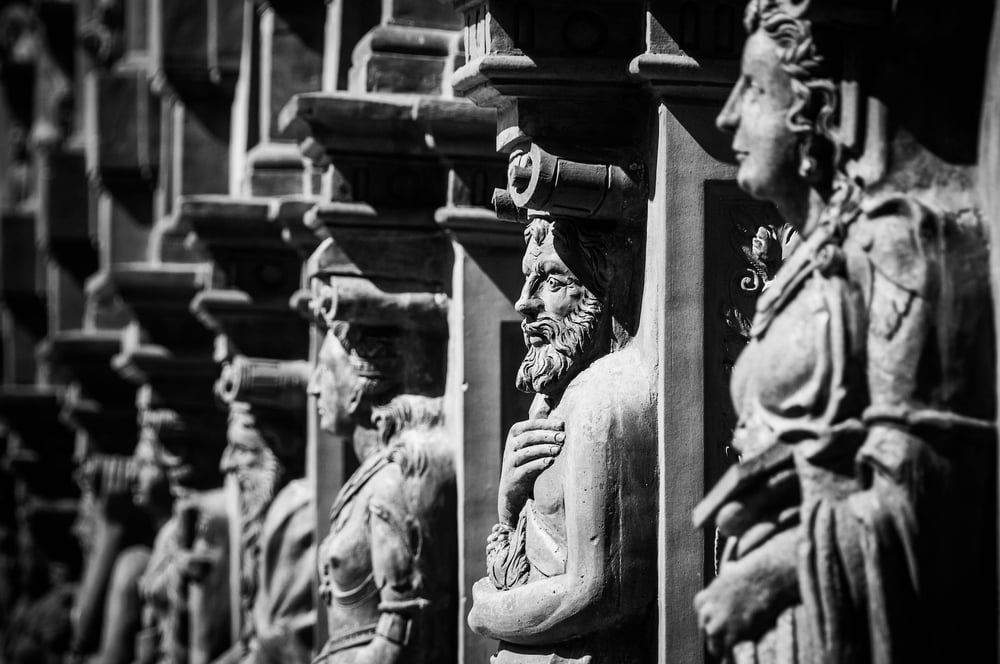 A row of Renaissance sculptures in the wall of a structure.