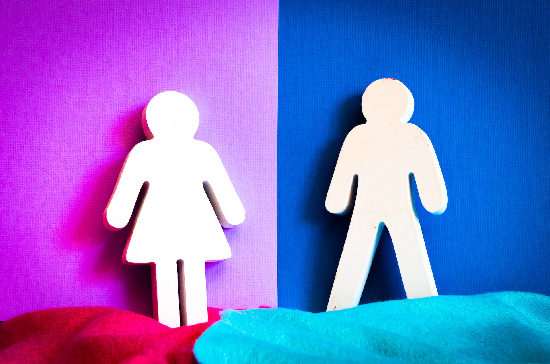 Woman and man stick figures against a pink and blue background.