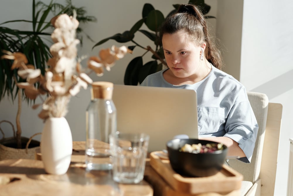 A writer sits at a computer looking intently at the screen.