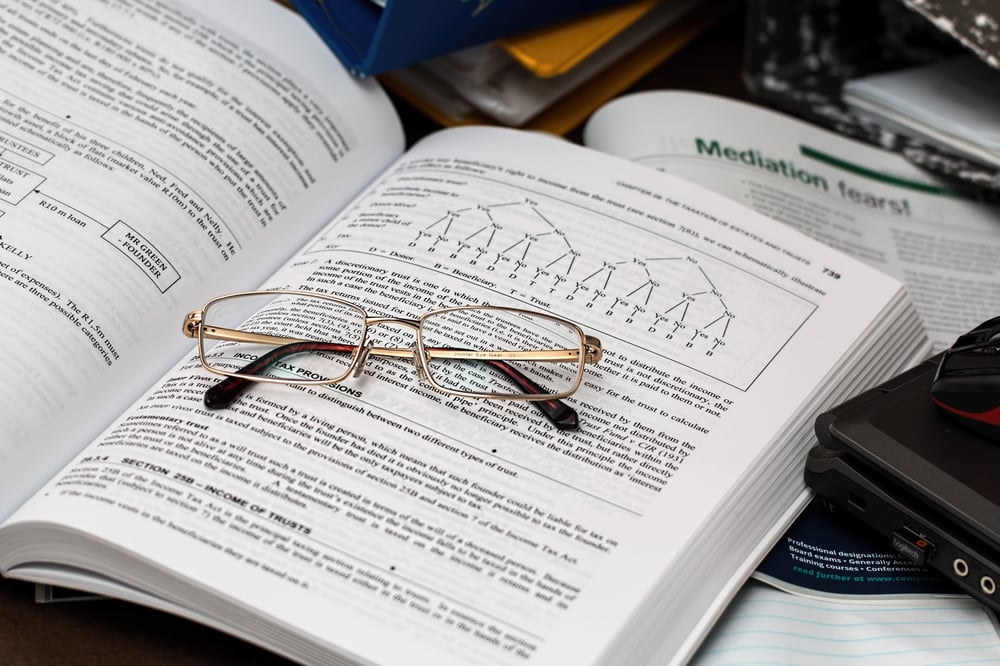 A pair of glasses on an open textbook.