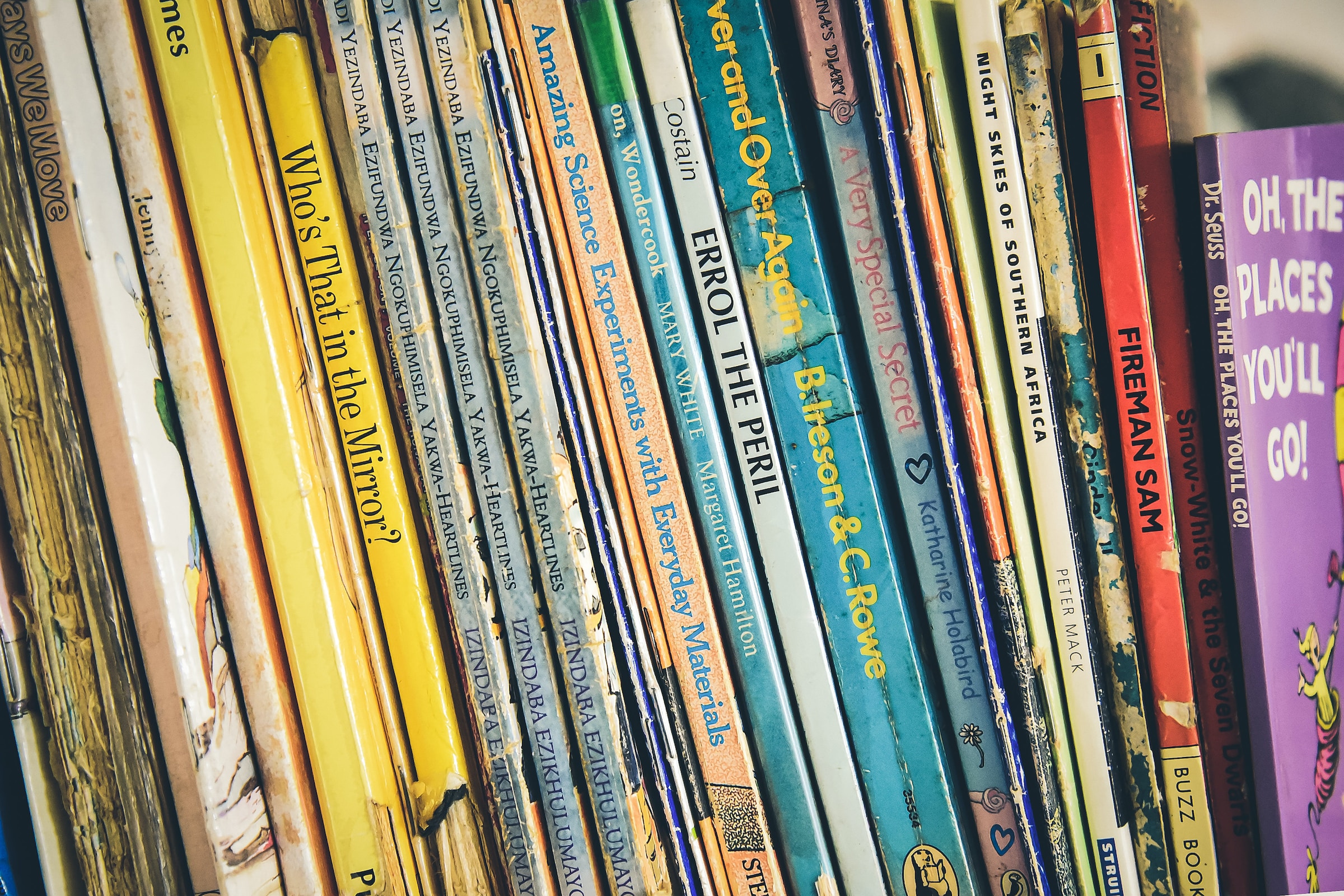 The spines of children's books on a shelf.