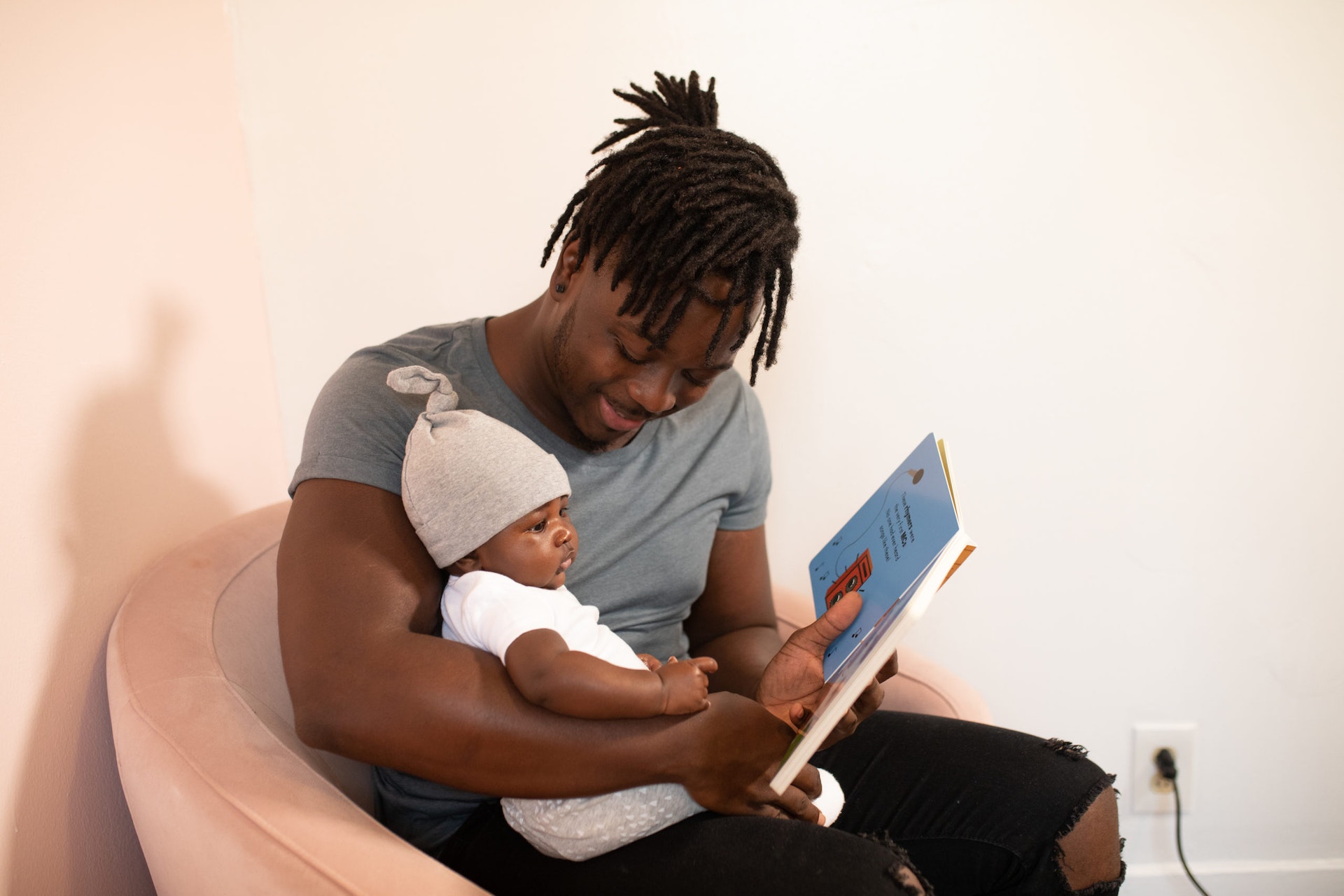 A parent reads a picture book to their baby.