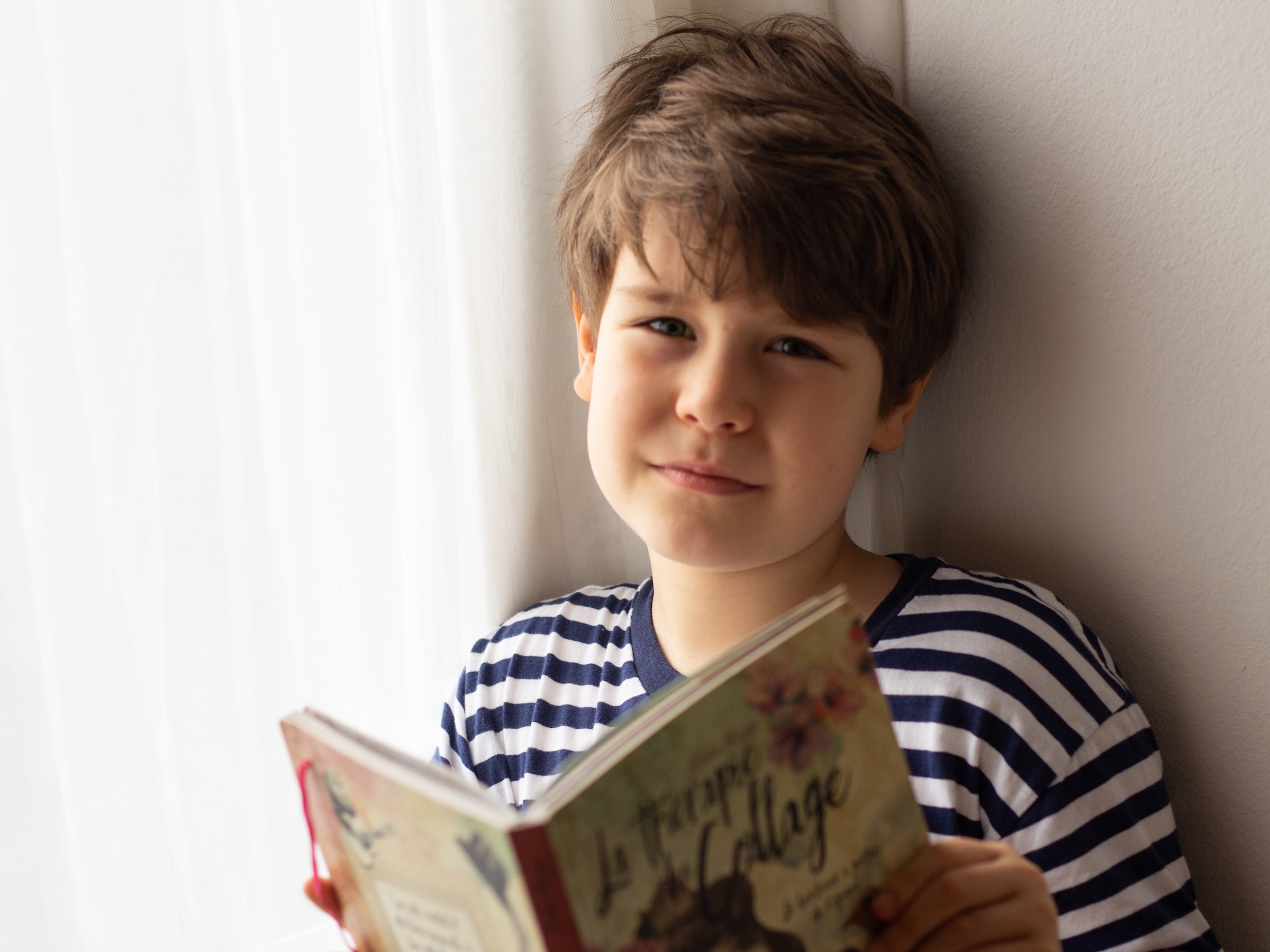 A child holds an open chapter book.