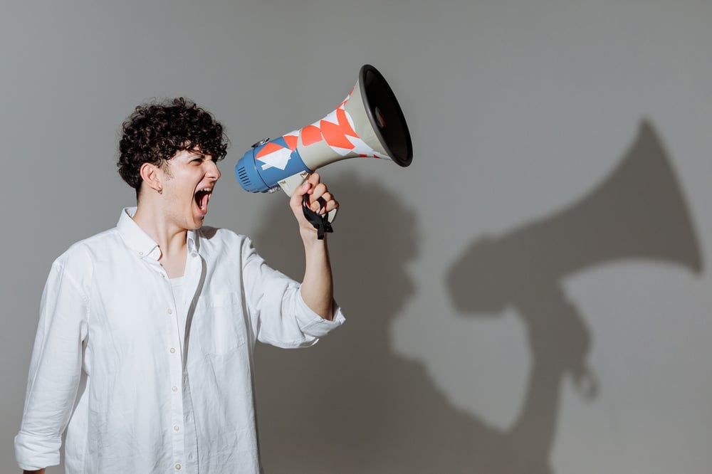 A person screams into a bullhorn.