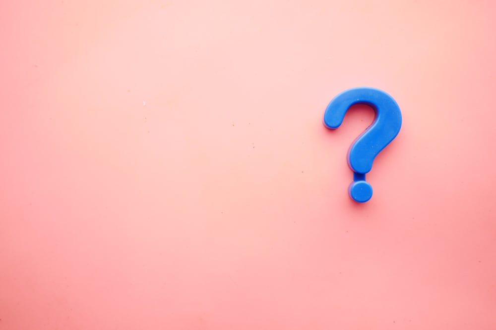 Blue question mark on pink background.