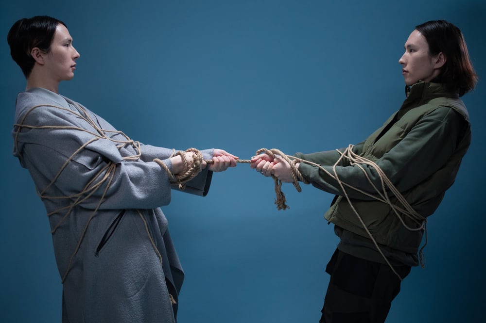 Two people pull on opposite sides of the same rope.
