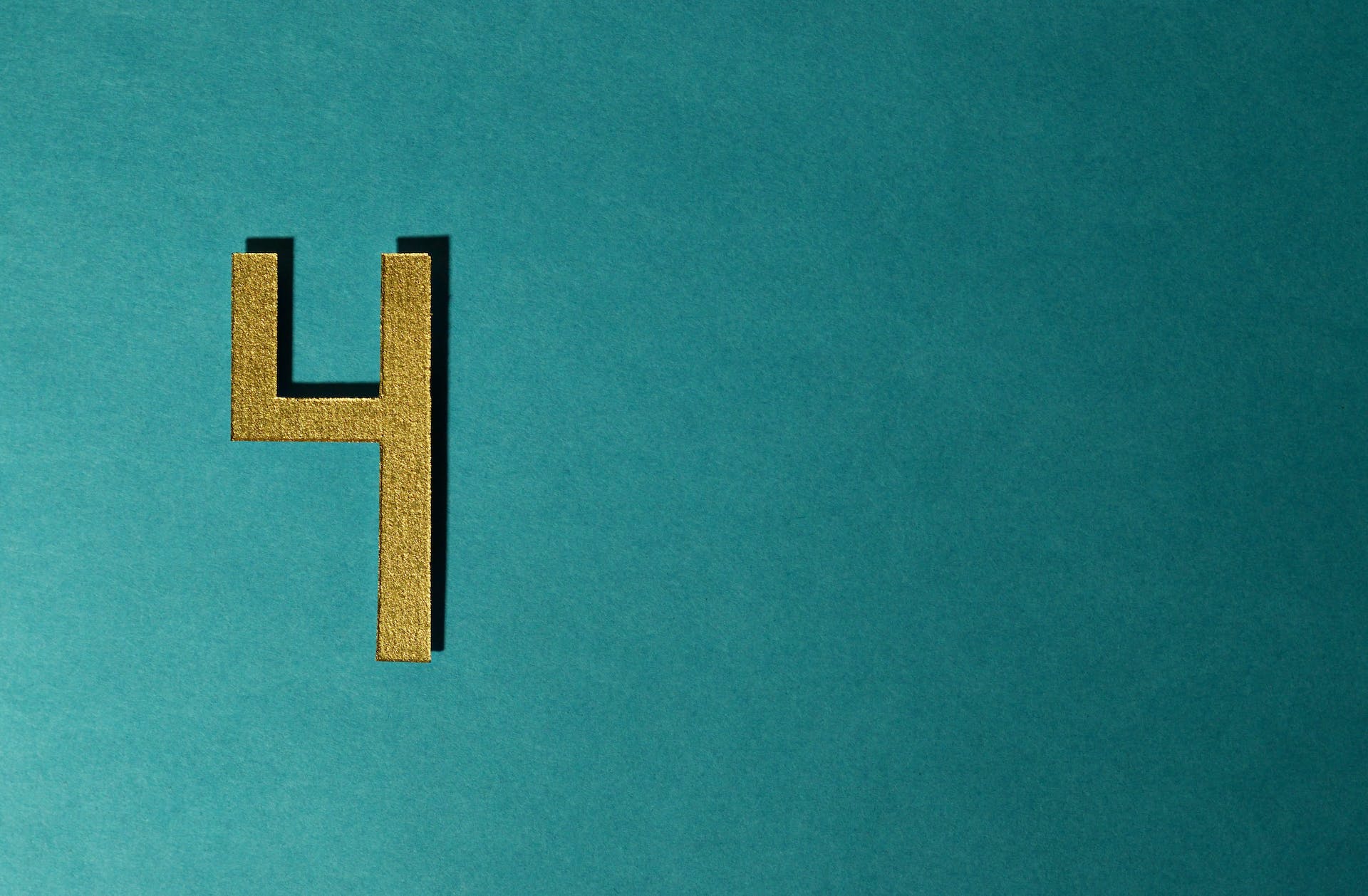 A gold number four against a teal background.