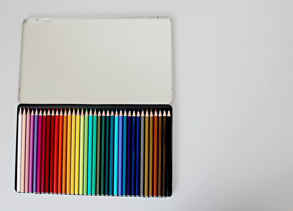 An open tin of colored pencils.