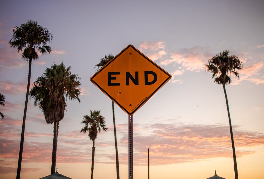 Palm trees and a sign reading "END."