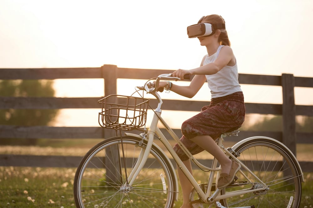 A person wears a VR headset while riding a bike.