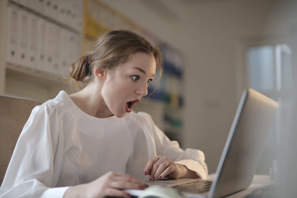 A person makes a shocked face as they read a computer screen.