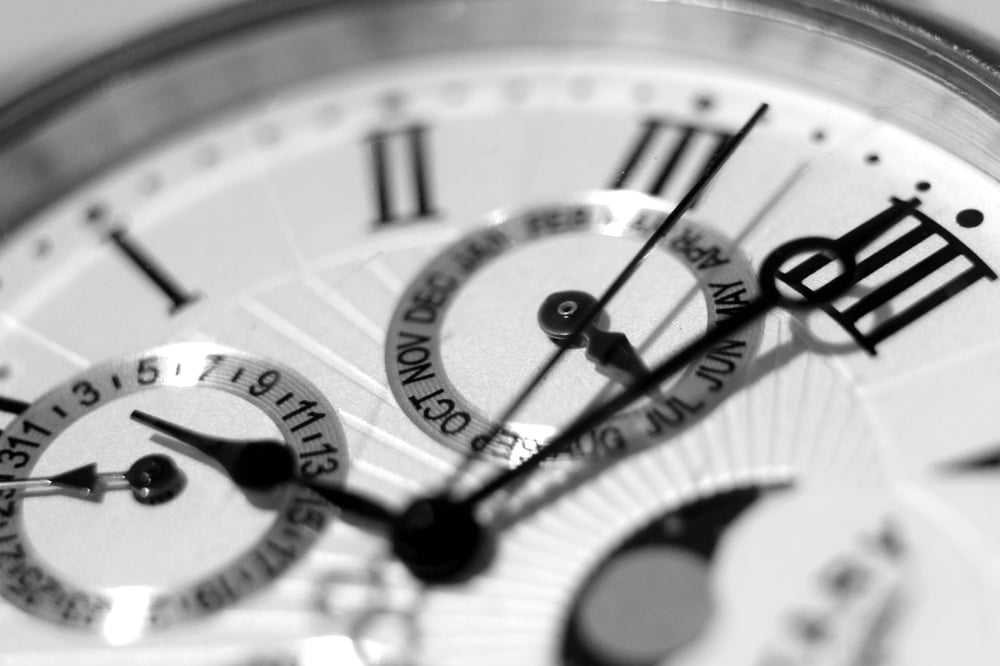 Close-up of the hands of a watch, representing the ticking clock trope.o