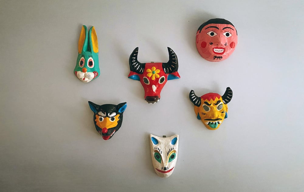 Colorful masks hanging on a wall.