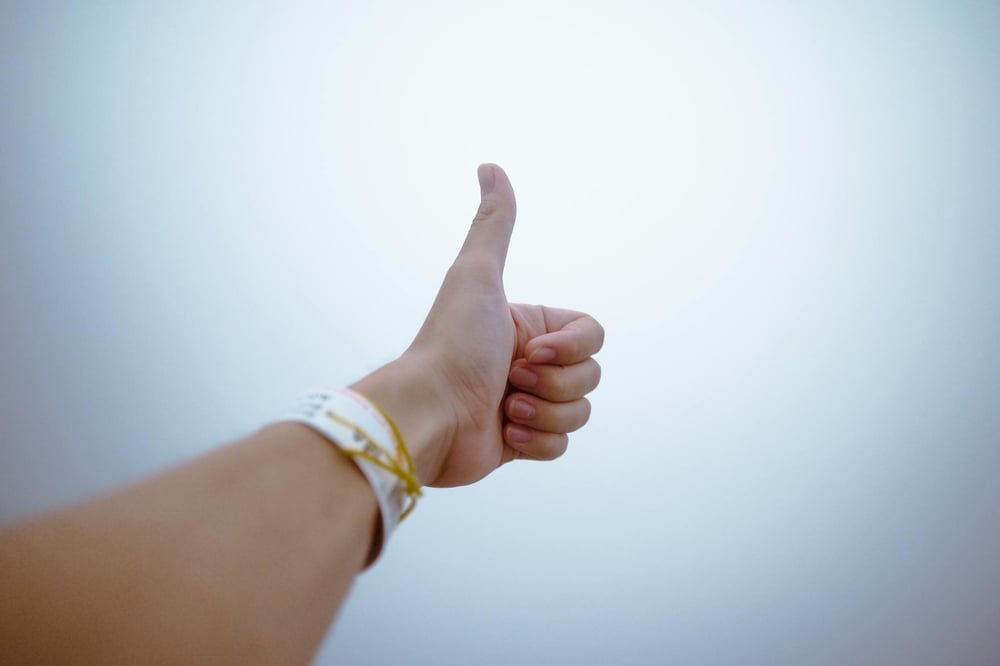 A hand gives a thumbs-up.