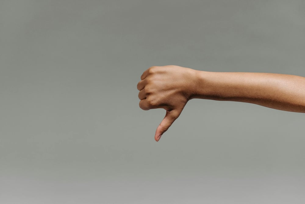 A hand gives a thumbs down.