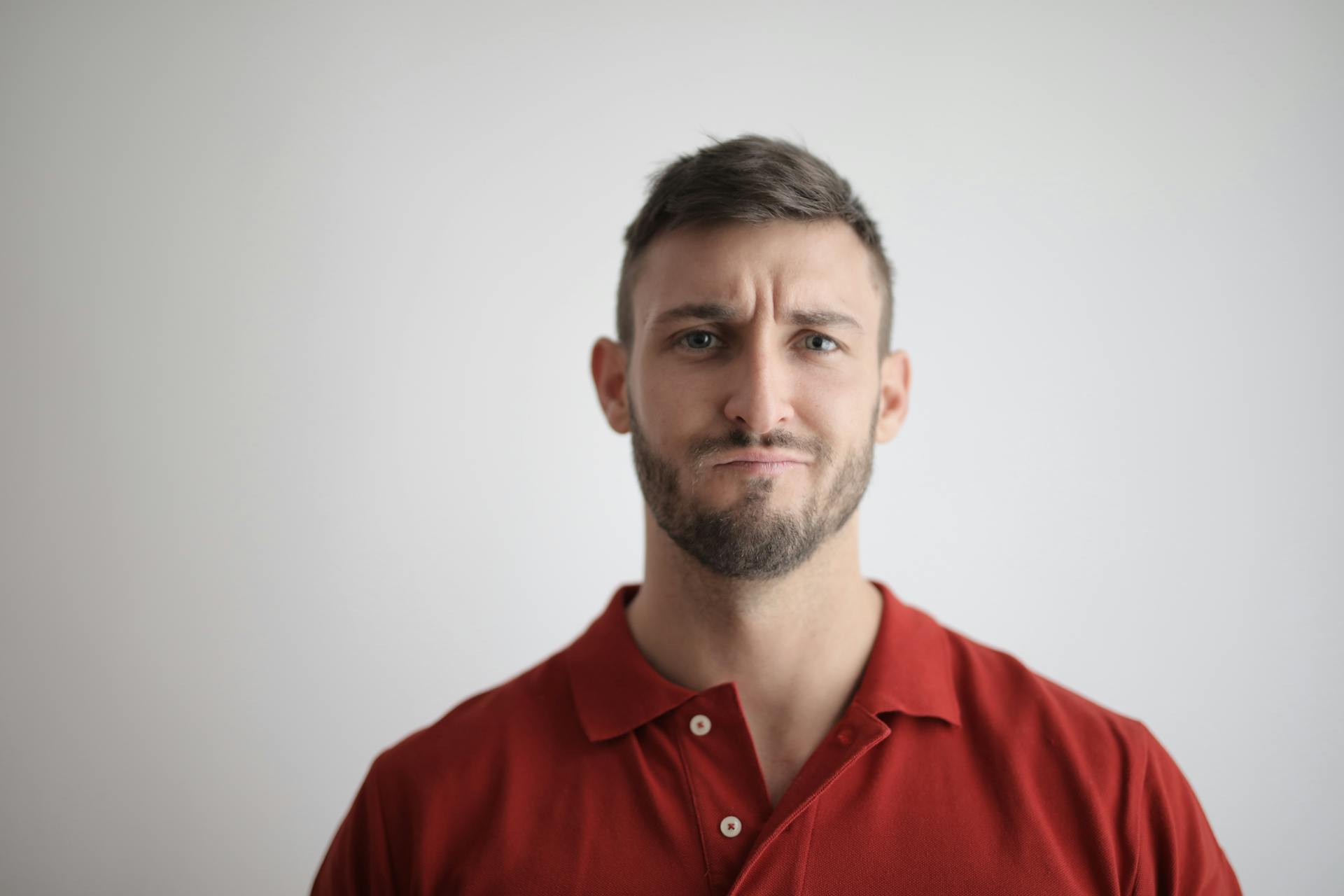 A person in a red shirt frowns.