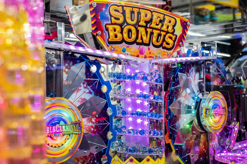 An arcade called Super Bonus has flashing lights and mirrored wheels.