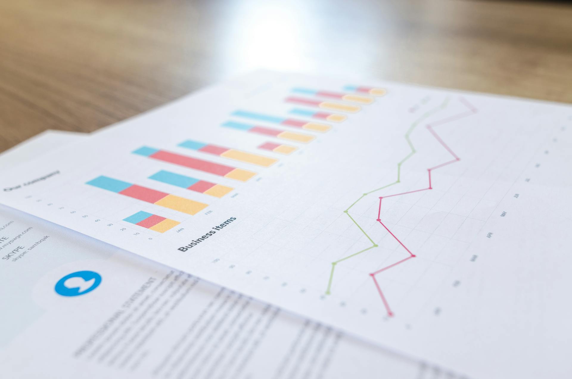 A paper showing graphs and charts sits on top of a technical document.