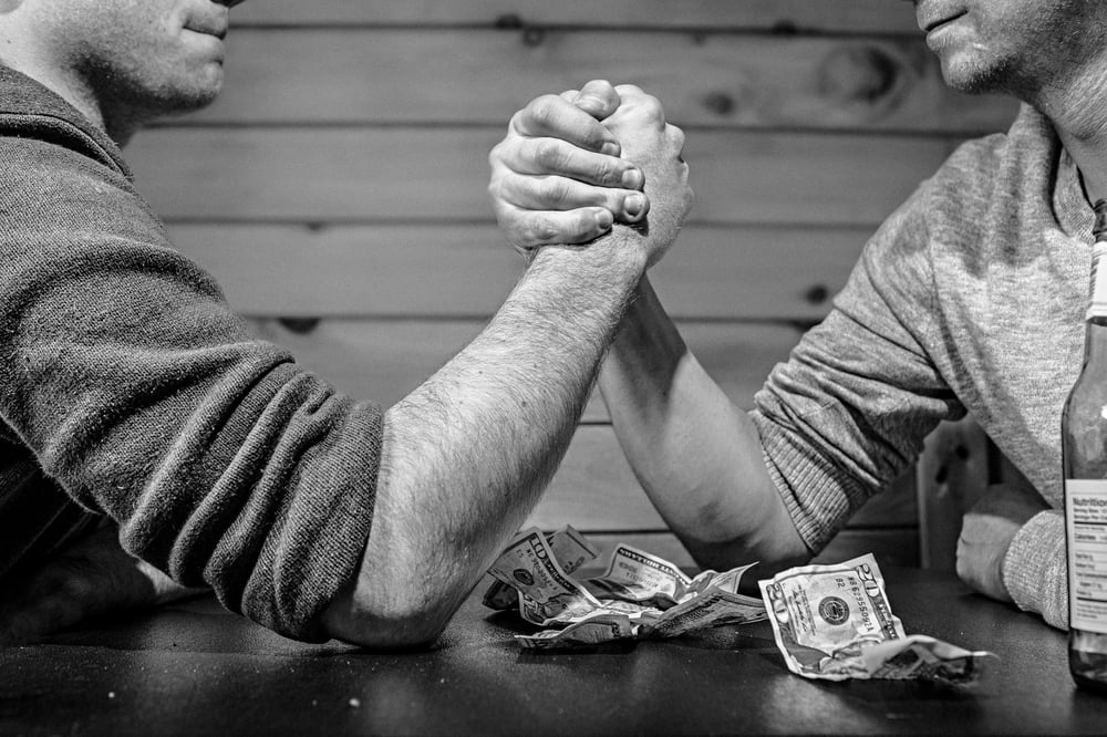 Two people arm wrestling in black and white.