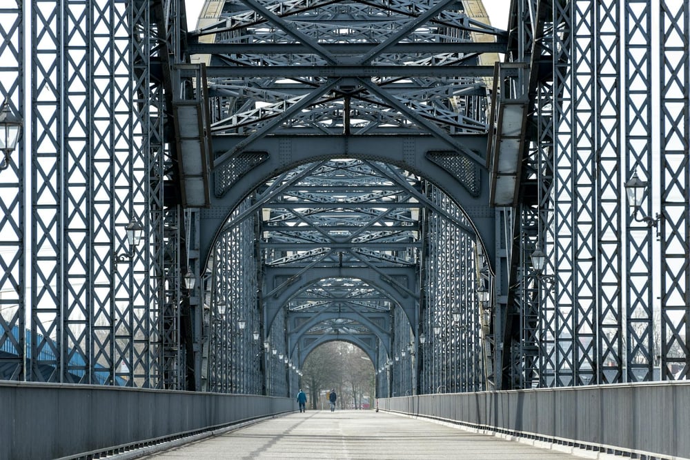 An ornate footbridge from the perspective of a person walking across it.
