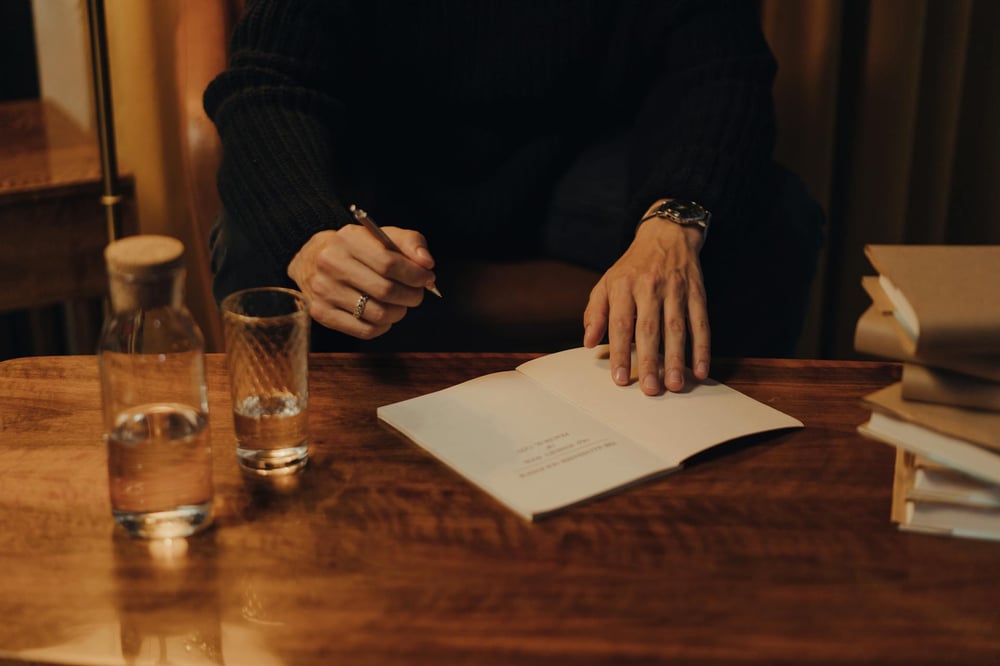 The hands of an author signing their book at a book signing event.