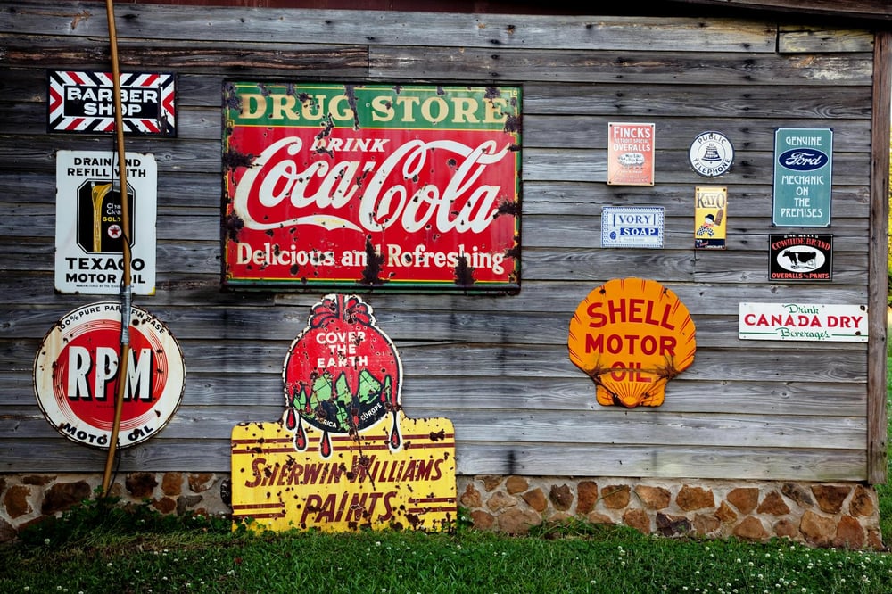 Vintage advertisements hanging on a distressed wooden wall.