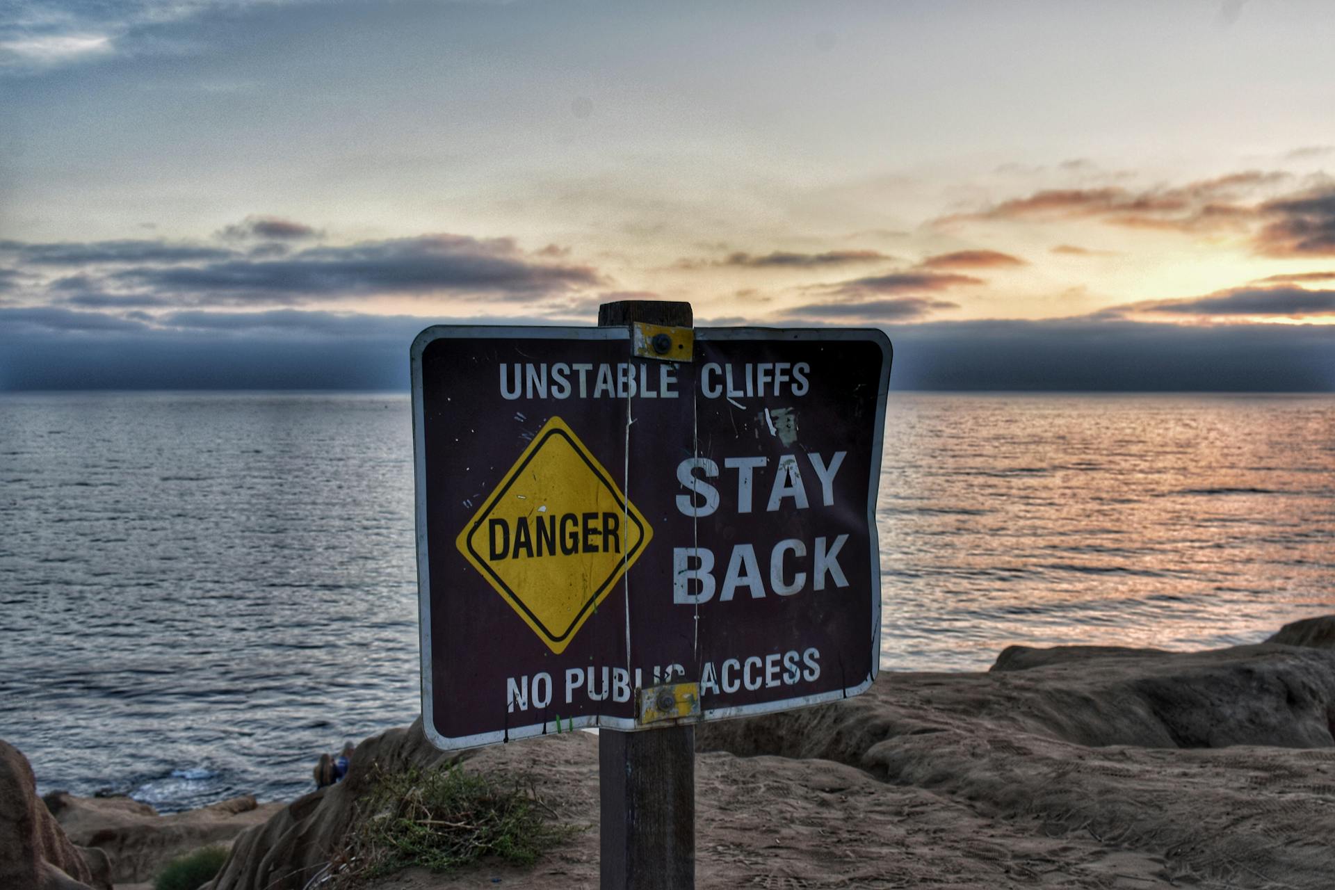 A danger sign on oceanside cliffs.