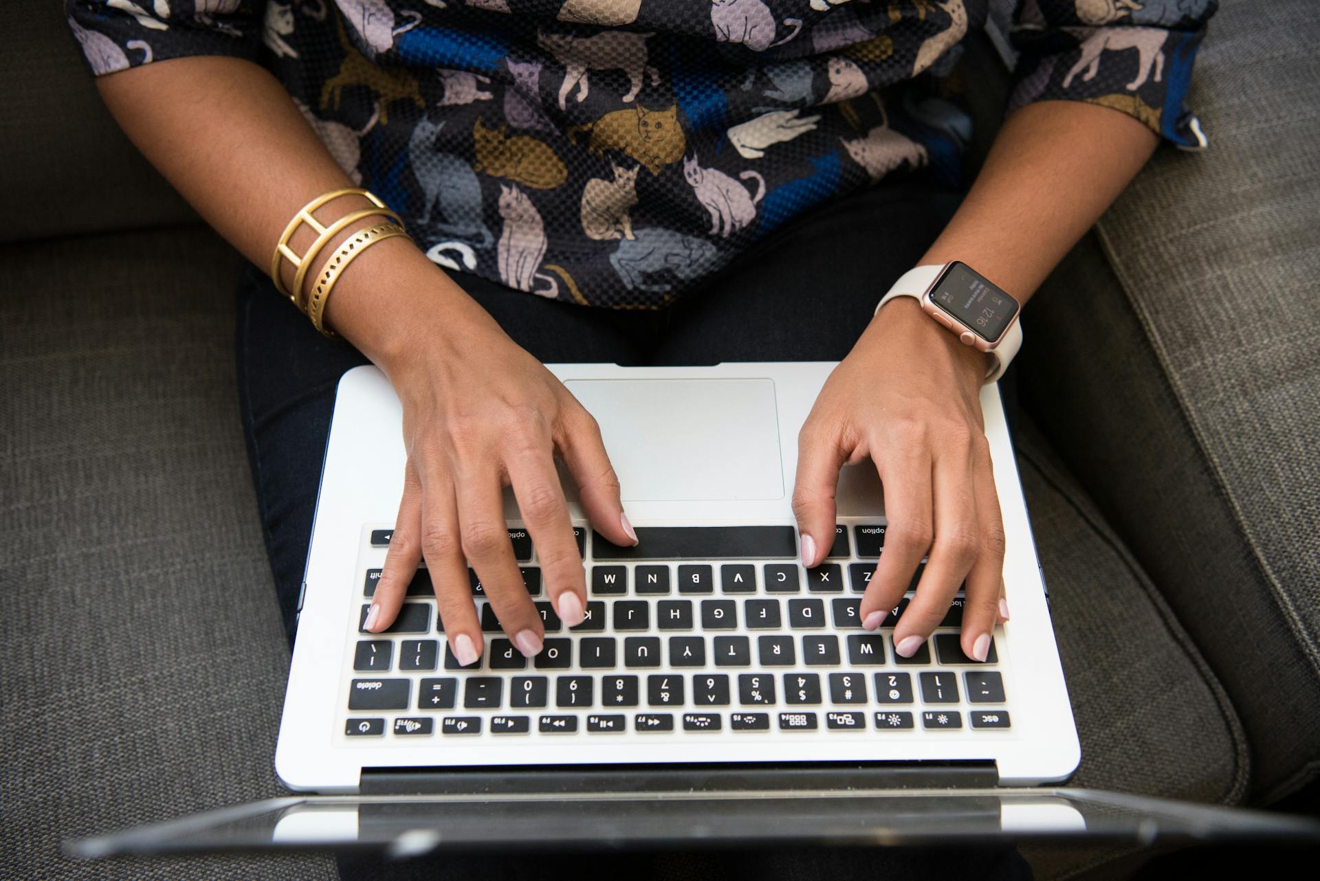 Hands type on a laptop.