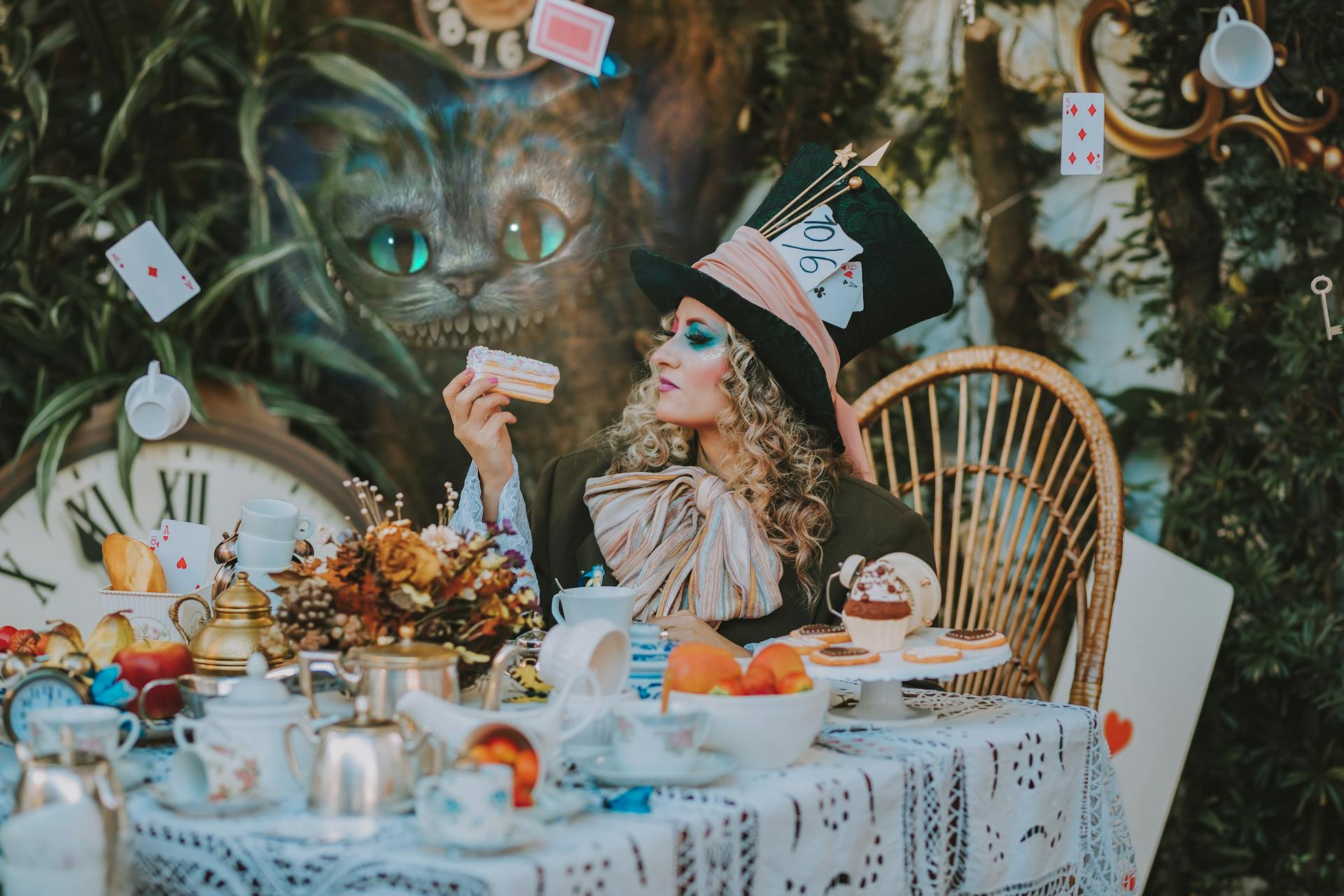 A person dressed as the Mad Hatter sits at a tea party table.