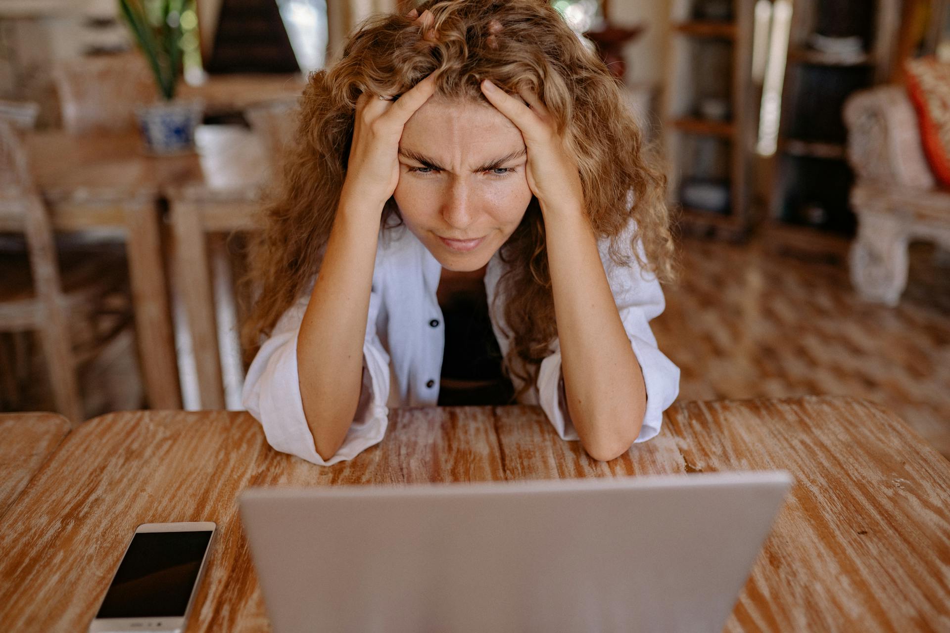 Stressed-looking person stares at a computer screen.