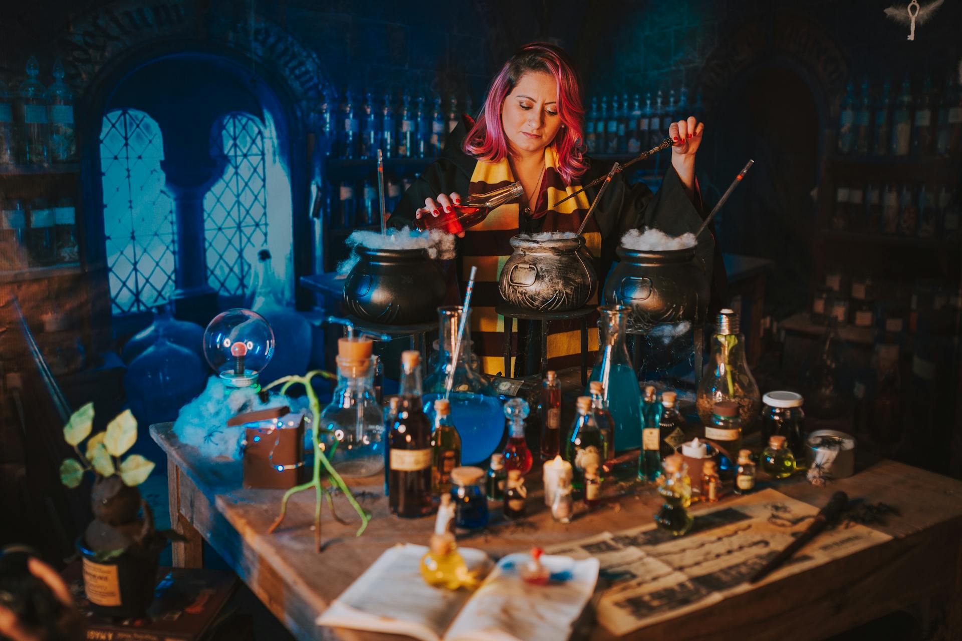 A person pours potions into a cauldron.