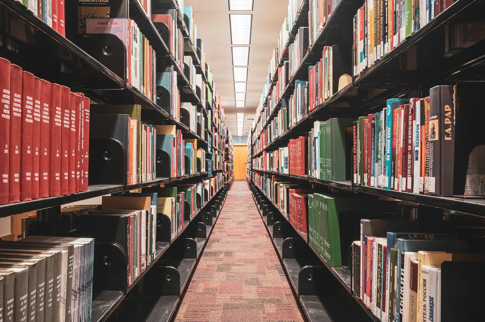 Looking down a long row of library bookshelves.
