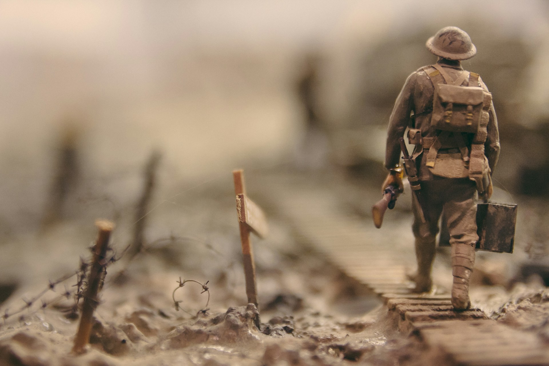 A miniature World War I soldier walks through a war zone.